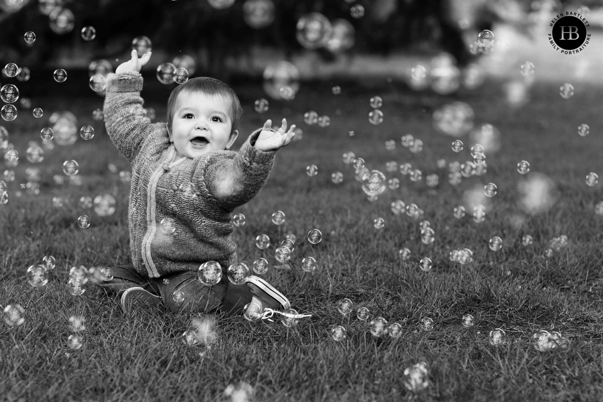 nine month old baby laughs with bubbles in park east london